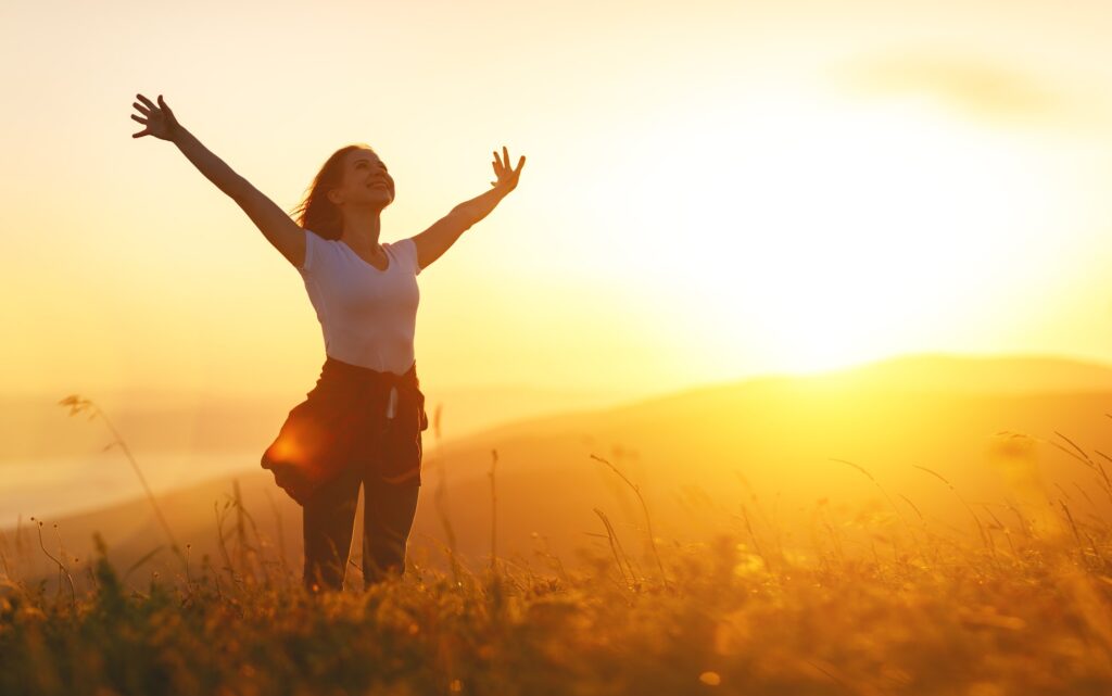 Happy Woman in the Sunset in Nature In Summer