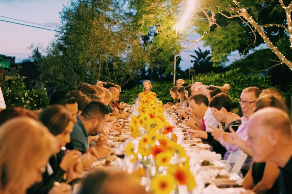 a group of people sitting at a long table